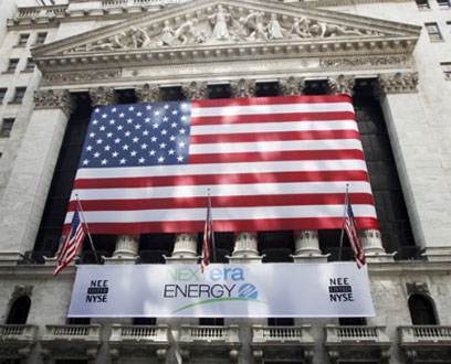 Wall street building with an American flag and NextEra Energy banner Wall street building with an American flag and NextEra Energy banner